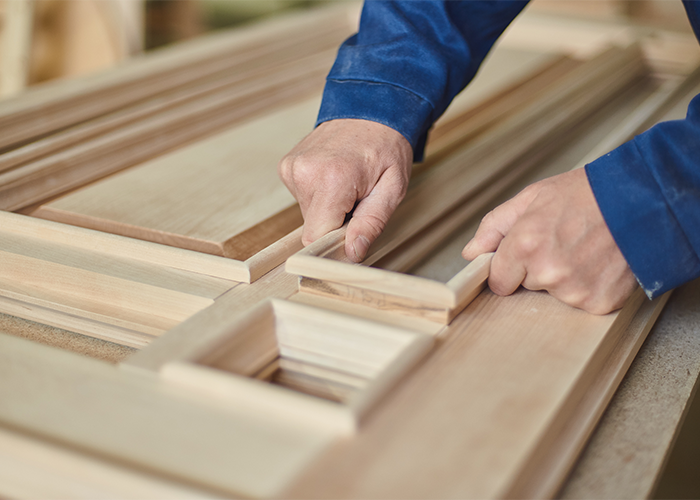 Handwerker bei der Bearbeitung von Holzelementen für Türen
